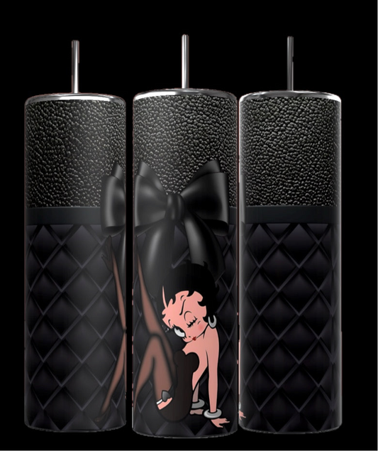 The Betty 20oz Skinny Tumbler by Kreative Kreationz features a black quilted texture with a silver lid and straw, showcasing Betty Boop in a pink dress on a bold black bow backdrop. Its spill-proof lid prevents leaks while you enjoy your drink.