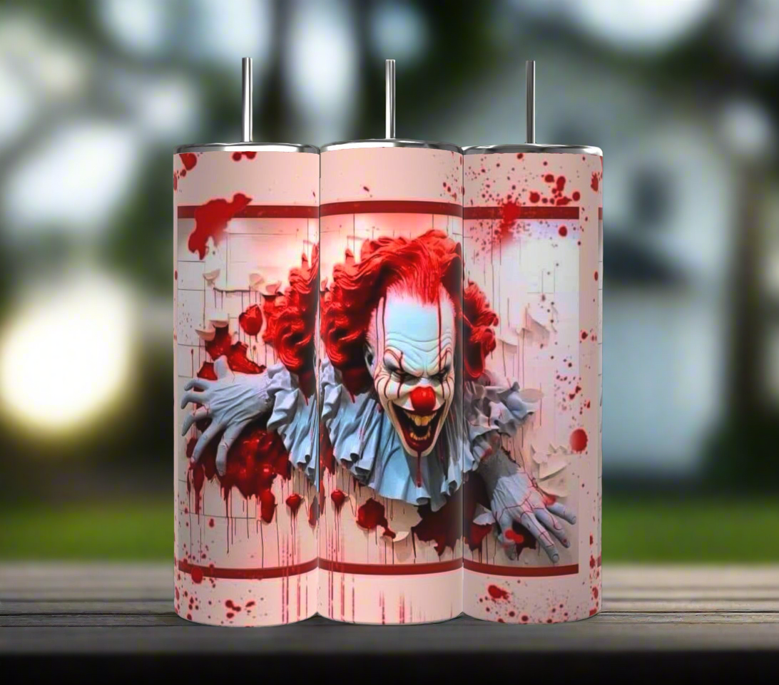 A set of three 20 oz tumblers from the Kreative Kreationz IT Halloween Series features a menacing clown with red hair and face paint, emerging through a blood-spattered background. The design shows the clown tearing through a white textured surface, enhancing the horror theme. Each tumbler includes a spill-proof lid.