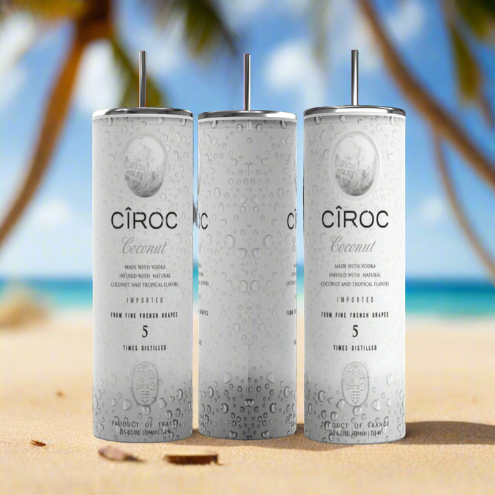 Two cans of Kreative Kreationz Ciroc 20oz Tumbler with 3D Lid Topper are shown on a wooden surface, reminiscent of travel tumblers. The left can is Red Berry flavor, topped with ice and a cherry. The right can is Vodka Snap Frost flavor, topped with ice and a lemon slice. Both cans feature product information and branding.