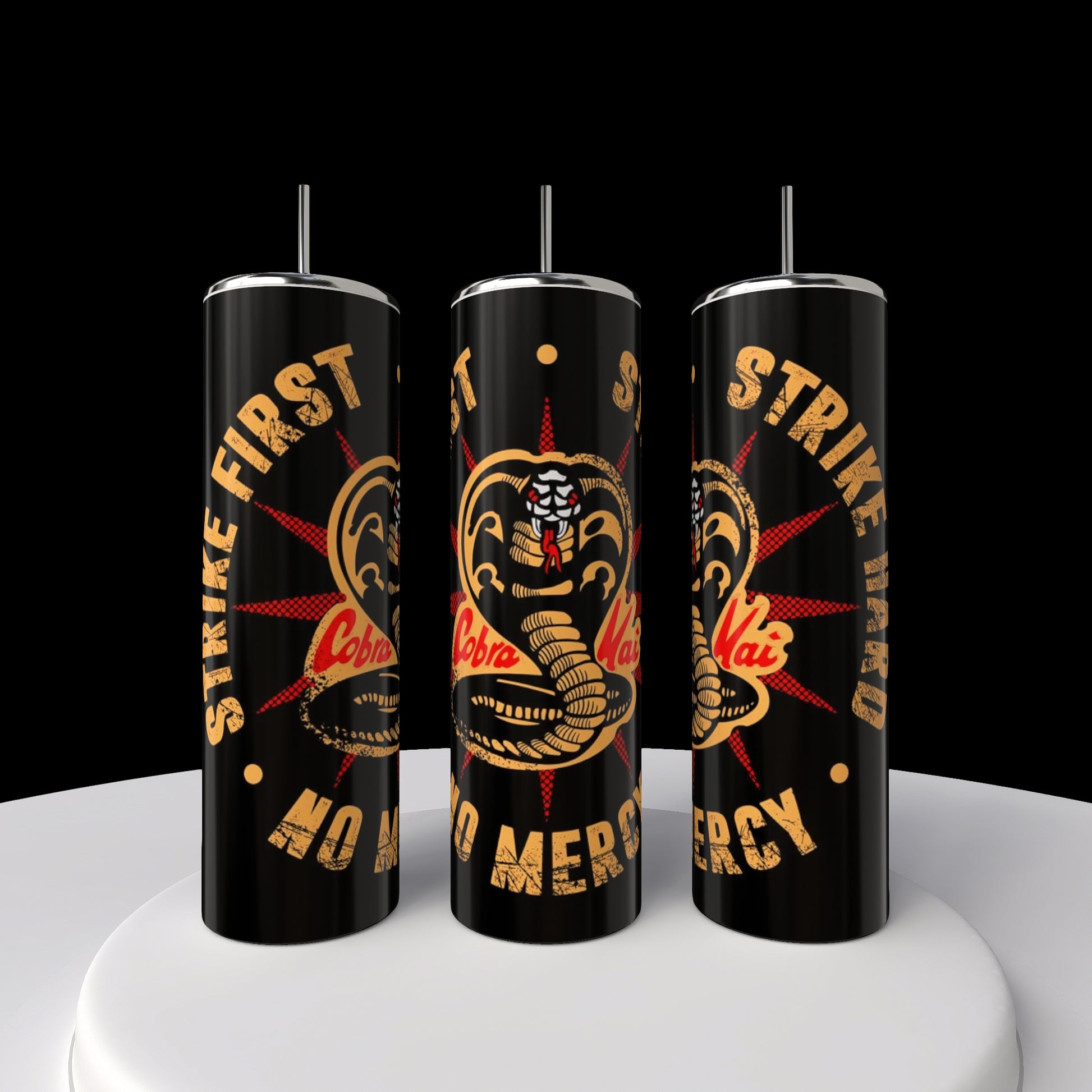 Three sleek black 20oz Kobra Kai tumblers by Kreative Kreationz, featuring lids and straws, display a stylized cobra logo. Bold text reads, "Strike First, Strike Hard, No Mercy." These stainless steel tumblers are set elegantly on a round white platform.