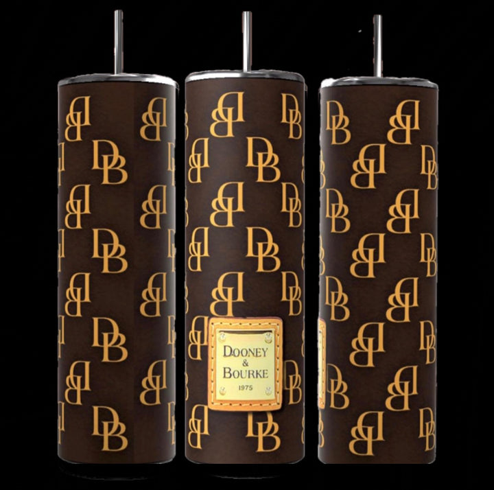 Three sophisticated 20oz tumblers, adorned with brown designs and gold "DB" patterns alongside a "Dooney & Bourke 1975" label. These insulated cylinders, from the Kreative Kreationz brand, combine style with functionality, featuring sleek silver lids and straws.