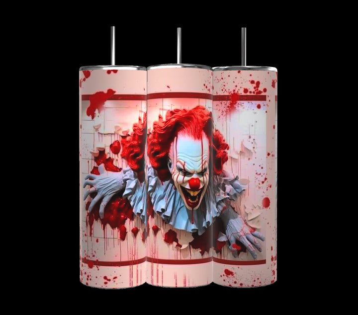 A set of three 20 oz tumblers from the Kreative Kreationz IT Halloween Series features a menacing clown with red hair and face paint, emerging through a blood-spattered background. The design shows the clown tearing through a white textured surface, enhancing the horror theme. Each tumbler includes a spill-proof lid.