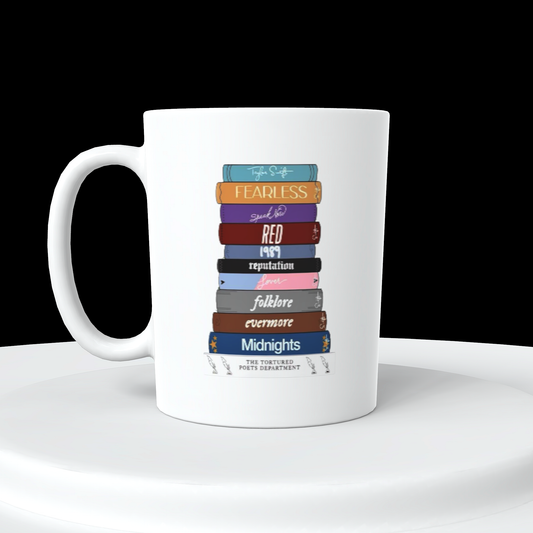 White ceramic coffee mug with Taylor Swifts albums stacked in book format with album names facing forward in order of release 