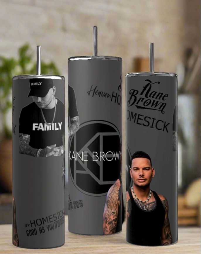 The Kane Brown 20oz Tumblers by Kreative Kreationz showcase a tattooed man with a cap and sleeveless top, featuring "Kane Brown," "FAMILY," "HOMESICK," and "Heaven" amid a blurred background, each crafted from high-quality stainless steel.