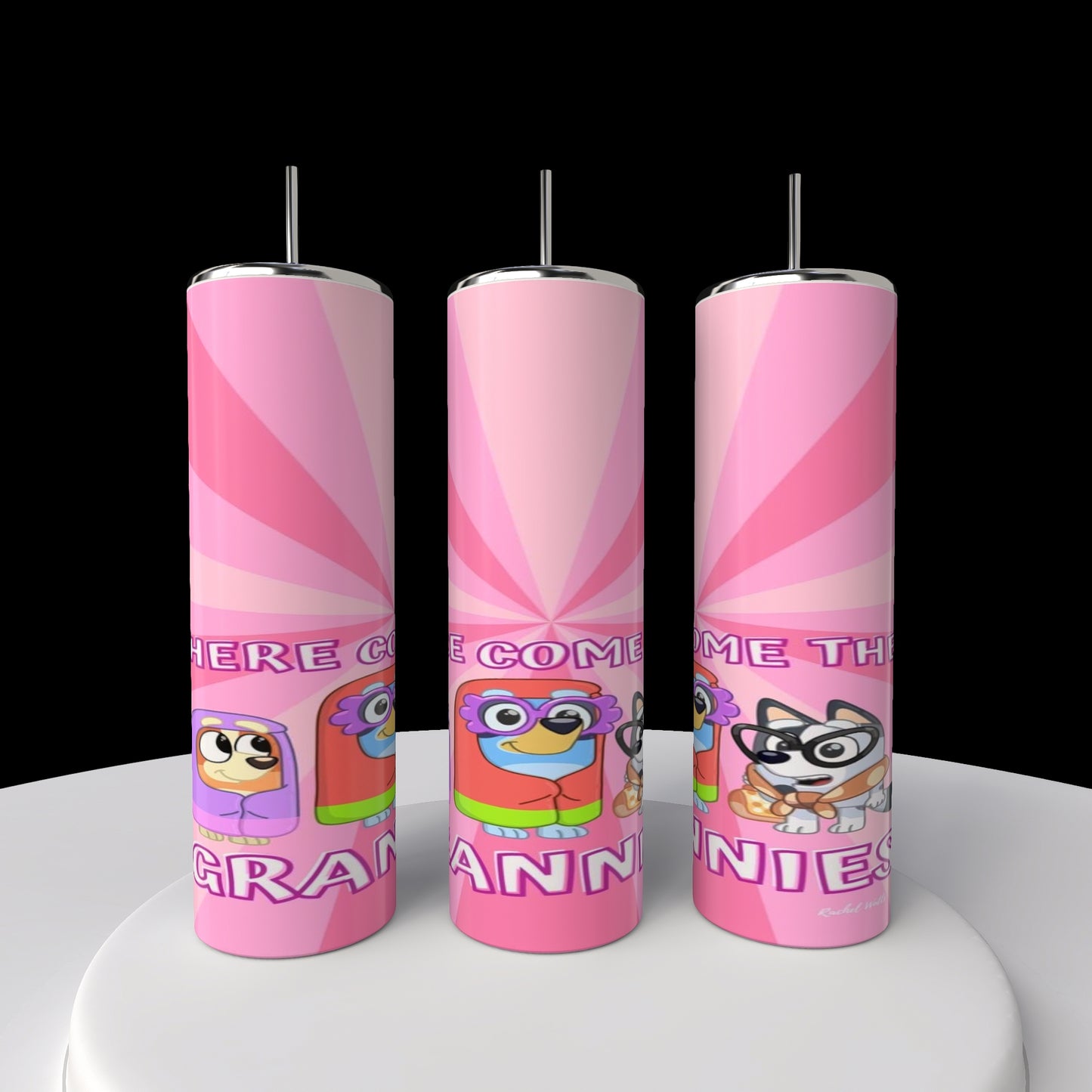 Three pink cylindrical tumblers from Kreative Kreationz with colorful cartoon characters in glasses and hats stand upright, reading "Here Come the Grannies!" These Bluey Grannies 20oz Stainless Steel Tumblers are displayed on a white surface against a black background.