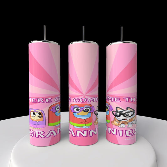 Three pink cylindrical tumblers from Kreative Kreationz with colorful cartoon characters in glasses and hats stand upright, reading "Here Come the Grannies!" These Bluey Grannies 20oz Stainless Steel Tumblers are displayed on a white surface against a black background.