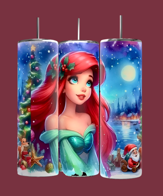 The Festive cylindrical lights resemble the Princess Ariel 20oz Tumbler by Kreative Kreationz, featuring an animated red-haired character in a green dress. The display captures the season's magic with cheer and creativity, as it is surrounded by a starry night, Christmas tree, reindeer, Santa Claus, and a snow-covered landscape.