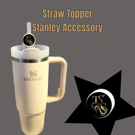 Beige Stanley cup with a handle and a round straw topper featuring a black background, letters, and dragon design. Reminiscent of the Kreative Kreationz Taylor Swift | REP Straw Topper. Text reads "Straw Topper Stanley Accessory" on gray. Perfect for Swifties.