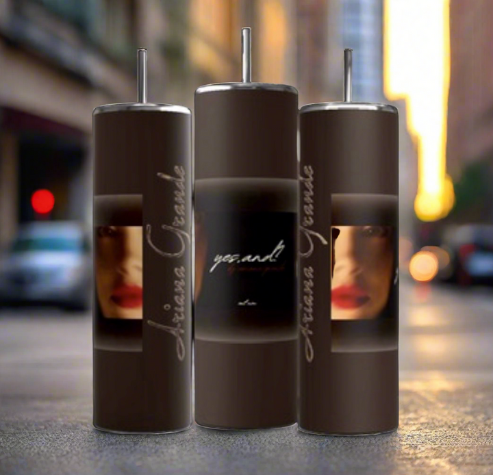 Three brown Ariana Grande External Sunshine 20-ounce skinny tumblers from Kreative Kreationz, complete with reusable metal straws, are displayed on a black background. Each tumbler features a partial image of a face with red lipstick and the text "Ariana Grande" and "yes.and".