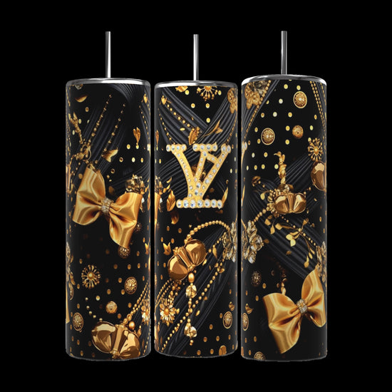 Three Kreative Kreationz Louis Vuitton Black and Gold 20oz Tumblers, adorned with elegant embellishments, are displayed on a kitchen counter. The center tumbler features an intricate Louis Vuitton monogram surrounded by gold bows, dots, and sparkles, reflecting a luxurious theme.