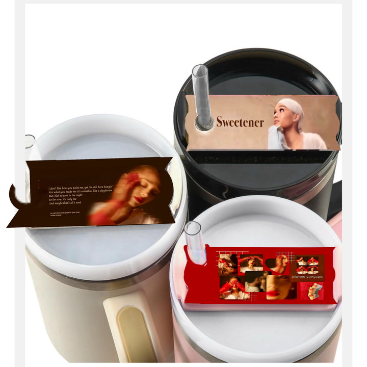 Three cylindrical containers are topped with images resembling Kreative Kreationz's Ariana Grande Stanley lid Plate/Toppers. The top container has an image labeled "Sweetener," featuring a woman wearing a headwrap. The two bottom containers showcase different images of a woman; one in a red-themed art style and the other in soft tones.