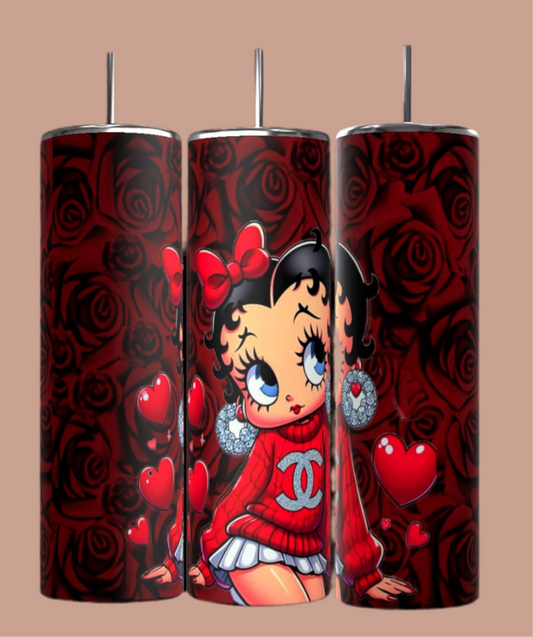 The Betty B 20oz Skinny Tumblers by Kreative Kreationz showcase a cartoon girl in a red outfit with hearts and roses against a floral background, complete with her signature red bow and large earrings. Each Betty Boop tumbler comes with a convenient reusable straw.