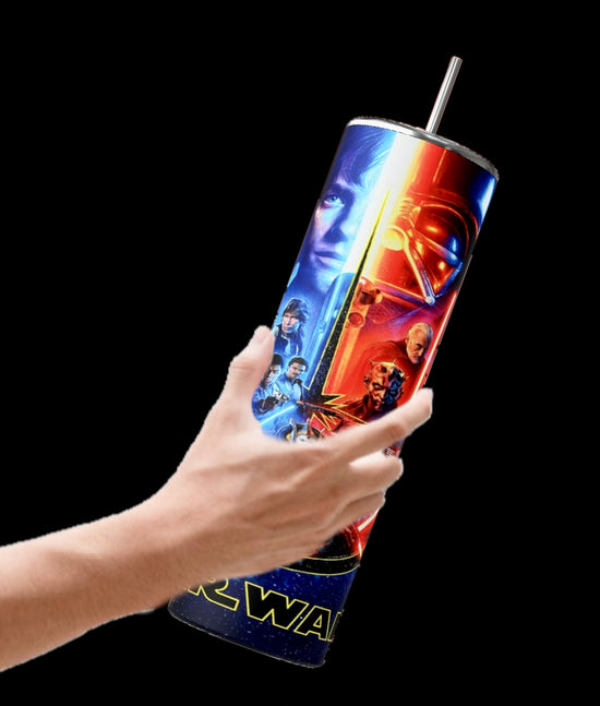 A hand holds the Kreative Kreationz Star Wars 20oz Tumbler, featuring vivid character and lightsaber images on a black background. Complete with a reusable straw and spill-proof lid, it's ideal for fans on the go.