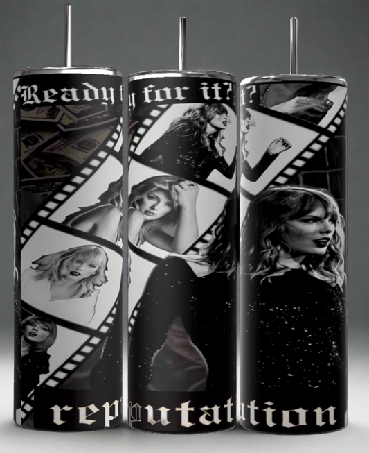 The REP 20oz Skinny Tumbler by Kreative Kreationz showcases a film strip design with black and white photos of a woman in various poses, featuring the words "Ready for it?" and "Reputation," adding a sleek elegance to its artistic appeal.