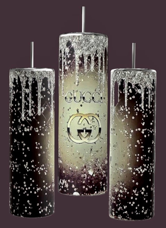 Three cylindrical tumblers featuring a striking black-to-silver gradient design with white speckles and icy drips, each topped with silver metallic lids and straws. The center tumbler, known as the Gucci Drop 20oz Tumbler by Kreative Kreationz, is crafted for durability and prominently displays the "GUCCI" logo alongside the iconic interlocking G's emblem.