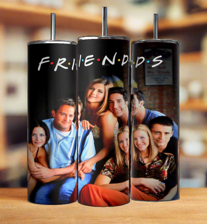 Three tall, stainless steel Friends Tv Show 20oz Tumblers-Group from Kreative Kreationz are displayed side by side. Each tumbler, featuring double-wall insulation, showcases images of the cast from the iconic 90s sitcom against a blurred background. The center tumbler has "F.R.I.E.N.D.S" written across the top in colorful letters.