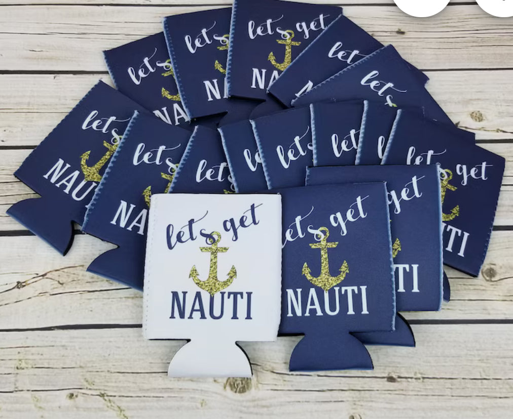 A set of Nautical Beach Theme 6-Pack Customizable Koozies from Kreative Kreationz is scattered on a wooden surface. These navy blue and white coolers are adorned with a gold anchor design and the phrase "Let's get NAUTI" in stylish lettering, making them ideal personalized party favors.