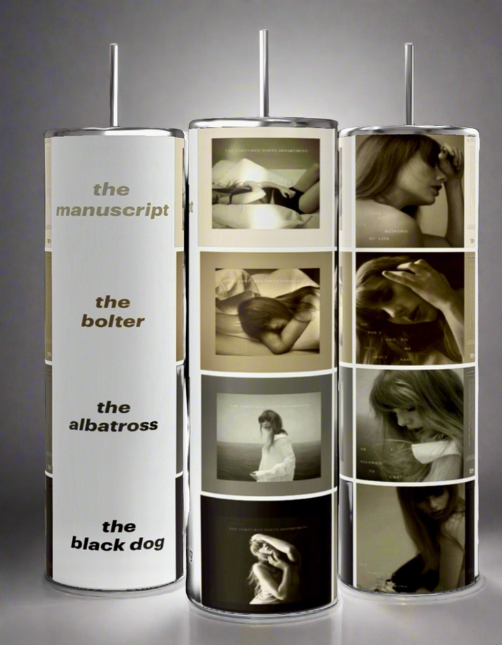 Three cylindrical stands display various monochromatic photographs of women in thoughtful and pensive poses. The left stand showcases titles "the manuscript," "the bolter," "the albatross," and "the black dog." Right next to them, a display features the Taylor Swift TTPD Collage 20oz Skinny Tumbler by Kreative Kreationz, equipped with a spill-proof lid.