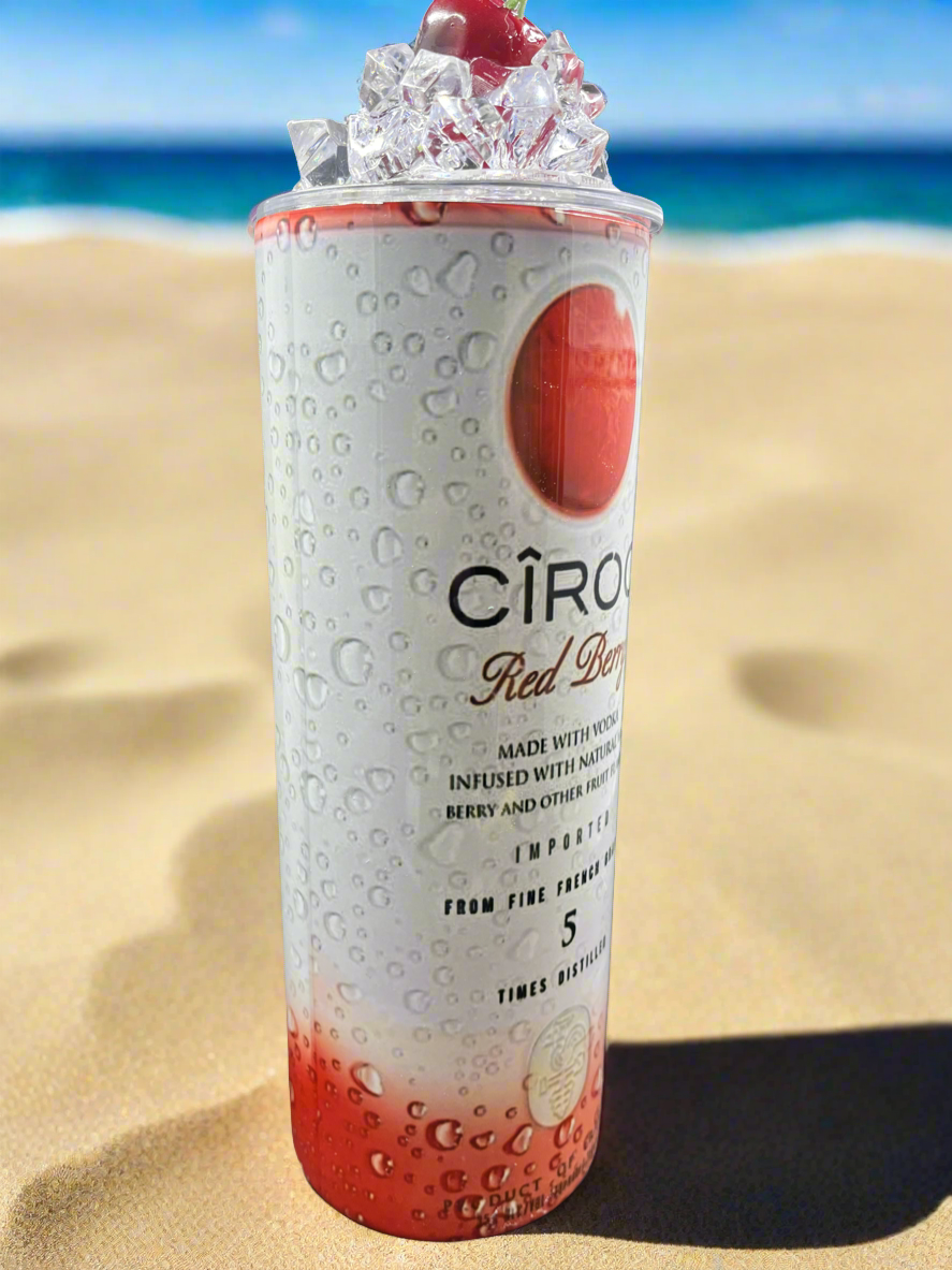 Two cans of Kreative Kreationz Ciroc 20oz Tumbler with 3D Lid Topper are shown on a wooden surface, reminiscent of travel tumblers. The left can is Red Berry flavor, topped with ice and a cherry. The right can is Vodka Snap Frost flavor, topped with ice and a lemon slice. Both cans feature product information and branding.