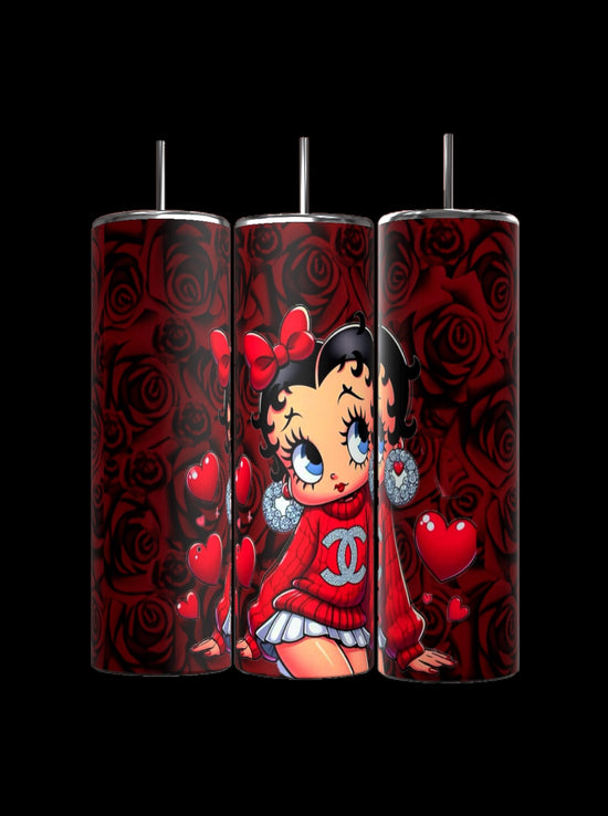 Kreative Kreationz's Betty B 20oz Skinny Tumbler showcases large-eyed cartoon characters in red sweaters and bows, with red roses and heart-shaped balloons on a black background. Each tumbler includes a reusable straw for stylish sipping.