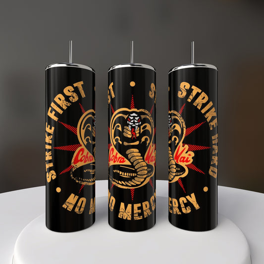 Kreative Kreationz offers three striking Kobra Kai 20oz stainless steel tumblers, featuring a black design with a coiled snake and "Cobra Kai" in red. The phrase "Strike First, Strike Hard, No Mercy" shines in gold on them, elegantly showcased on a round surface.