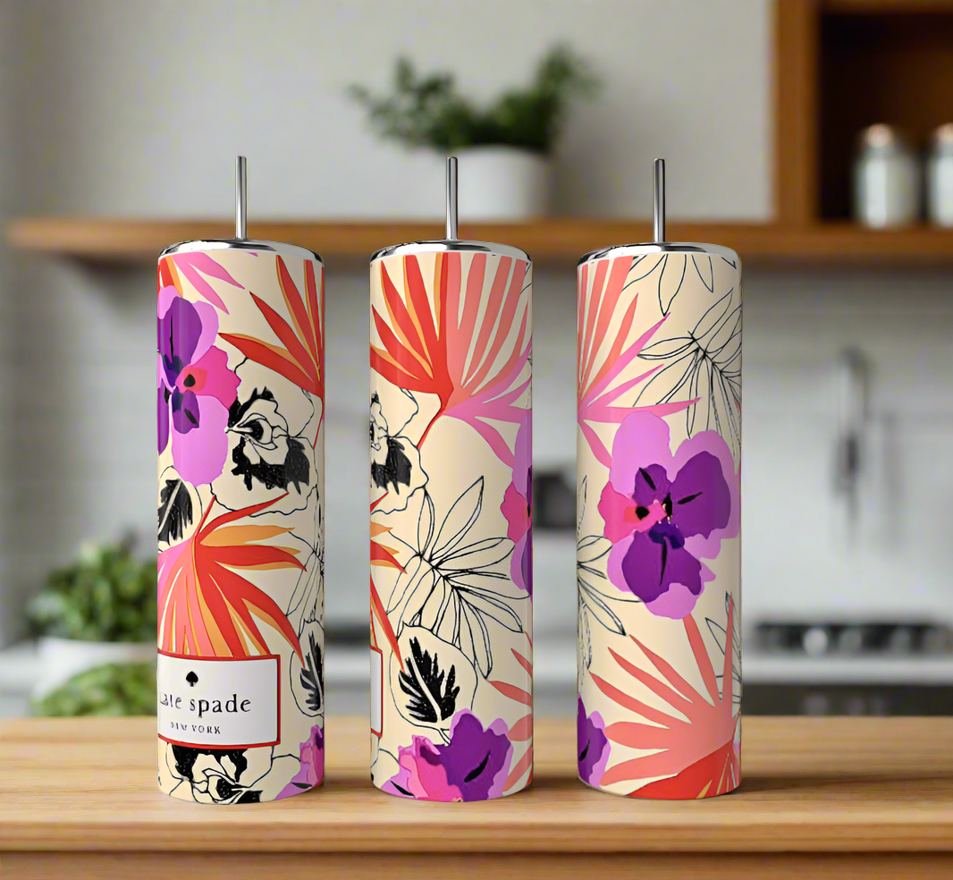 A trio of Kate Spade Floral 20oz Skinny Tumblers from Kreative Kreationz, adorned with purple and pink flowers and green leaves on a light background, are showcased on wood against a blurred kitchen backdrop, adding an eco-friendly touch to the design.