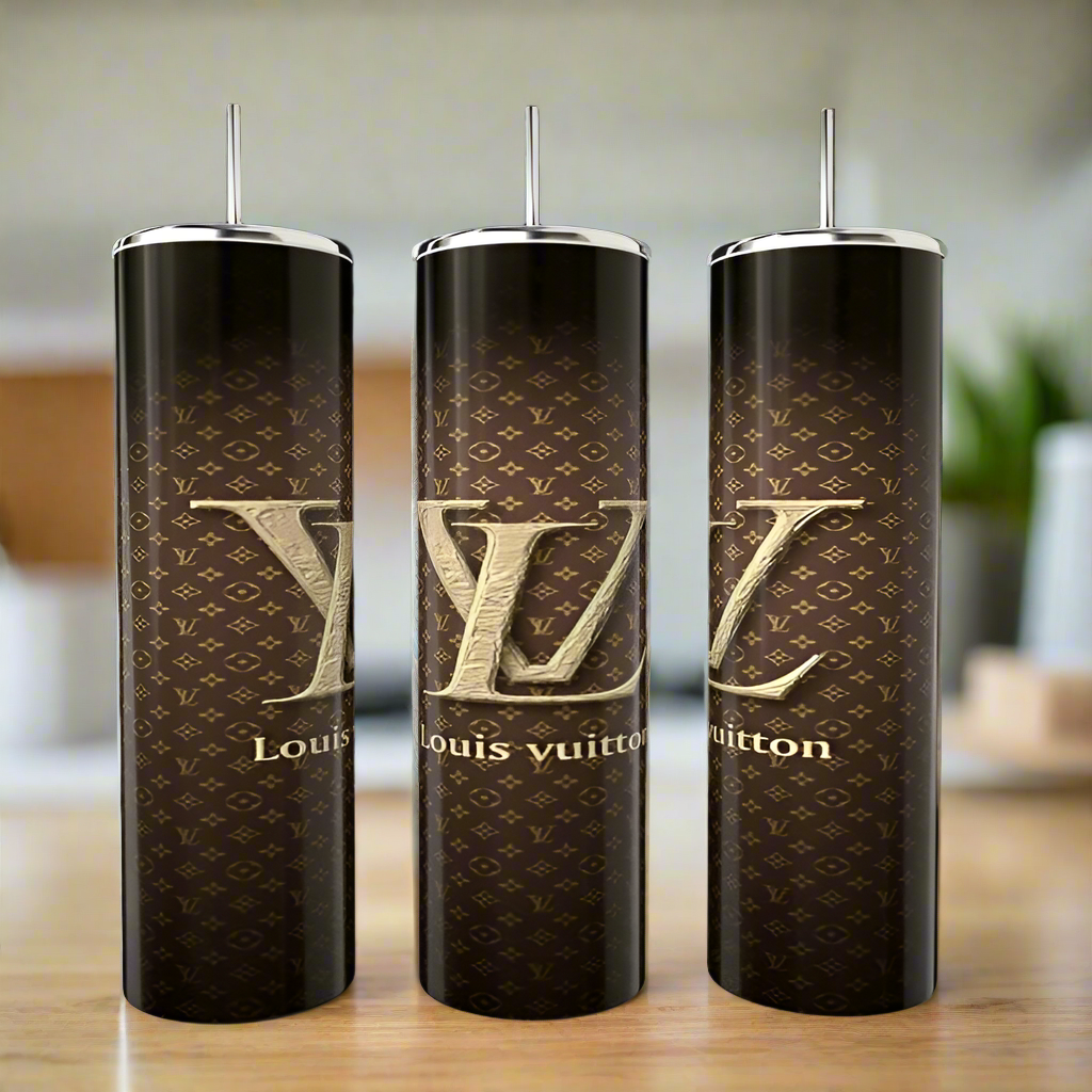 Three elegant 20oz Louis V Skinny Tumblers from Kreative Kreationz feature a luxurious Louis Vuitton monogram with large LV initials and "Louis Vuitton" text in brown and gold. Made from eco-friendly material, they come with shiny silver lids and straws set against a softly blurred background.