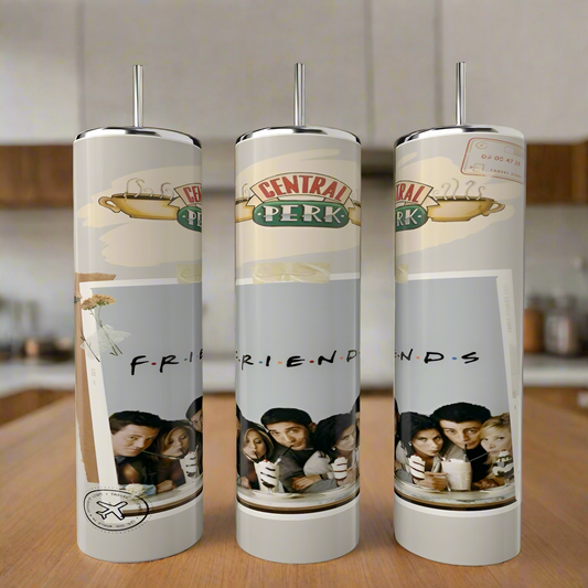 The Friends Poloraid Tumblers by Kreative Kreationz, featuring a coffeehouse design and an image of six friends with milkshakes and "F.R.I.E.N.D.S" beneath, are crafted from stainless steel. These stylish pieces rest on a wooden surface in a cozy kitchen setting.