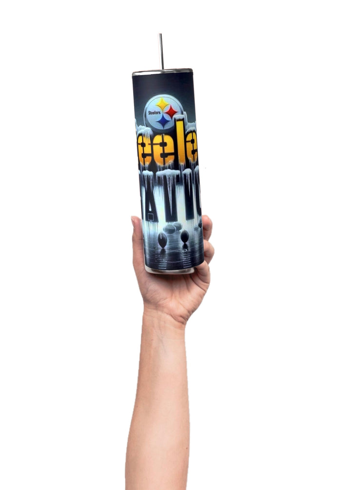 A hand holds a Kreative Kreationz Steelers Nation 20oz Skinny Tumbler featuring a vibrant football-themed design with "Steel Attitude" text and logo. It includes a silver metal straw and spill-proof lid, set against a dark, moody background.