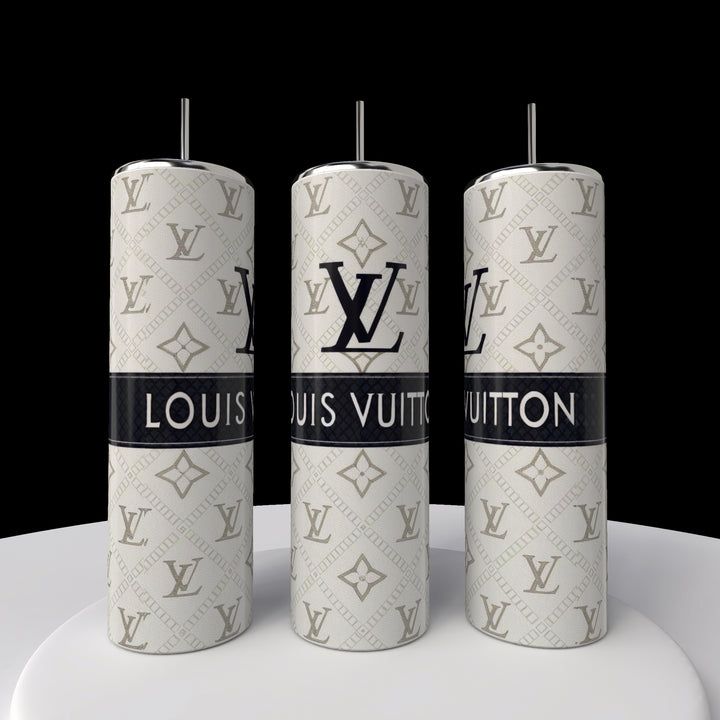 Three silver Kreative Kreationz LV 20oz Skinny Tumblers with straws are lined up on a white surface, showcasing black Louis Vuitton logos and branding on a patterned silver background. Their sleek, cylindrical design enhances the elegance against the black backdrop.