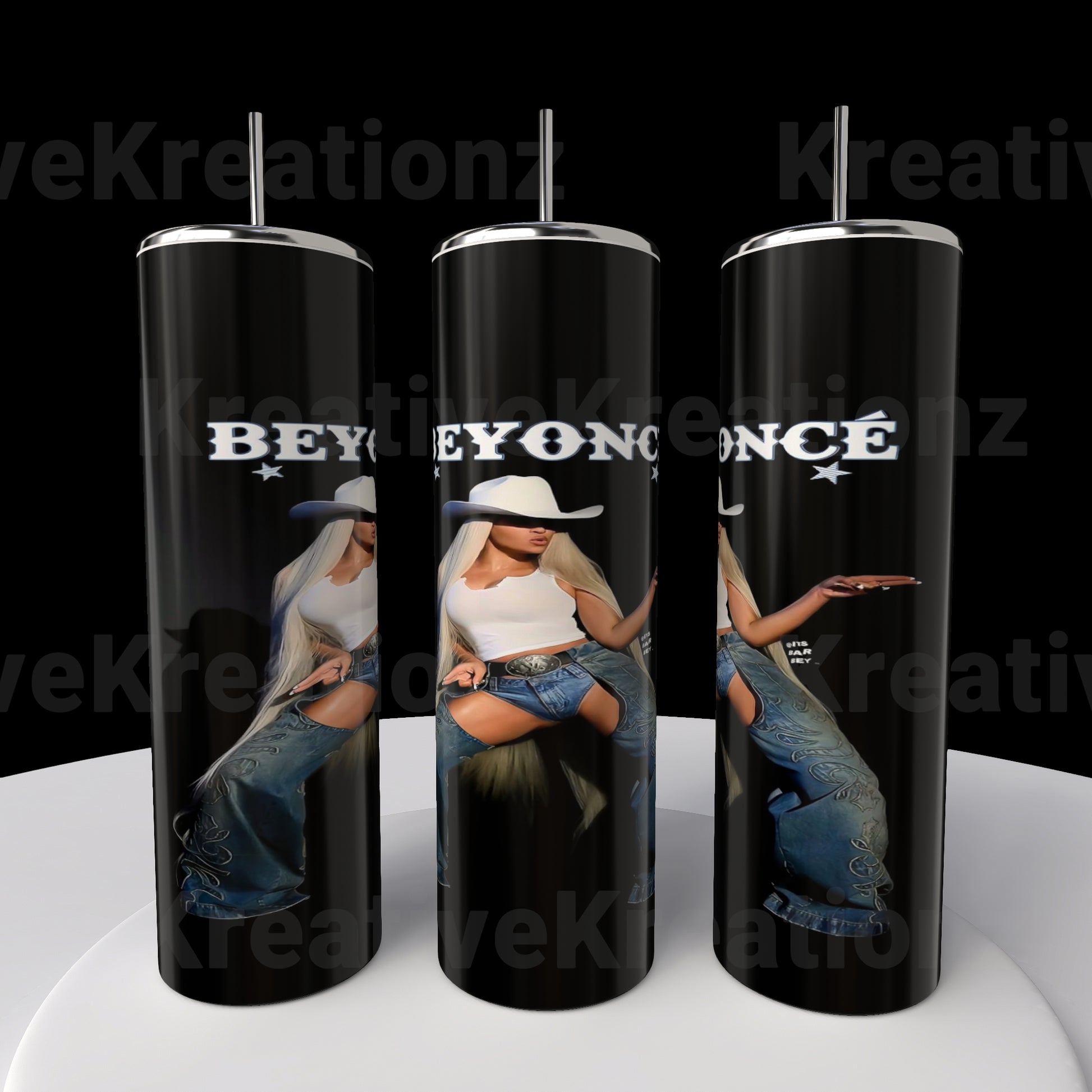 Three tall black stainless steel tumblers by Kreative Kreationz feature a woman in a cowboy hat and denim, with "BEYONCÉ" in bold white letters. These stunning Beyoncé 20oz sublimated tumblers are displayed on a round white surface.