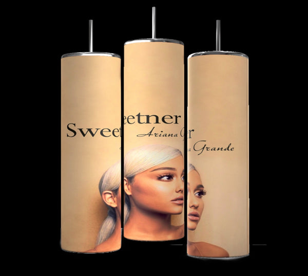 Three tall, cylindrical personalized tumblers with a beige background are displayed against a black backdrop. Each tumbler features a portrait image of a Ariana Grande with long, light-colored hair, along with text that includes the word "Sweetener" and the name Ariana Grande.