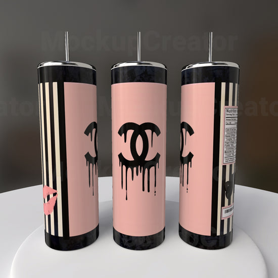 Three Chanel 20oz Skinny Tumblers by Kreative Kreationz are shown with pink and black hues, inspired designs featuring logos with a dripping effect, vertical stripes, and a lipstick mark. One tumbler displays a nutrition label, while the background is blurred for emphasis.