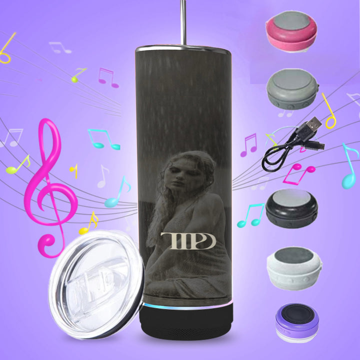 Three tall, cylindrical TTPD Bluetooth Tumblers with dark exteriors and pink bases are aligned. One side of each tumbler features a statue image and the letters "MP". An accompanying smartphone displaying an app is seen on the left. A USB cable, clear plastic cover, and a 20oz spill-proof lid tumbler are beside them. The Tumblers are branded by Kreative Kreationz.