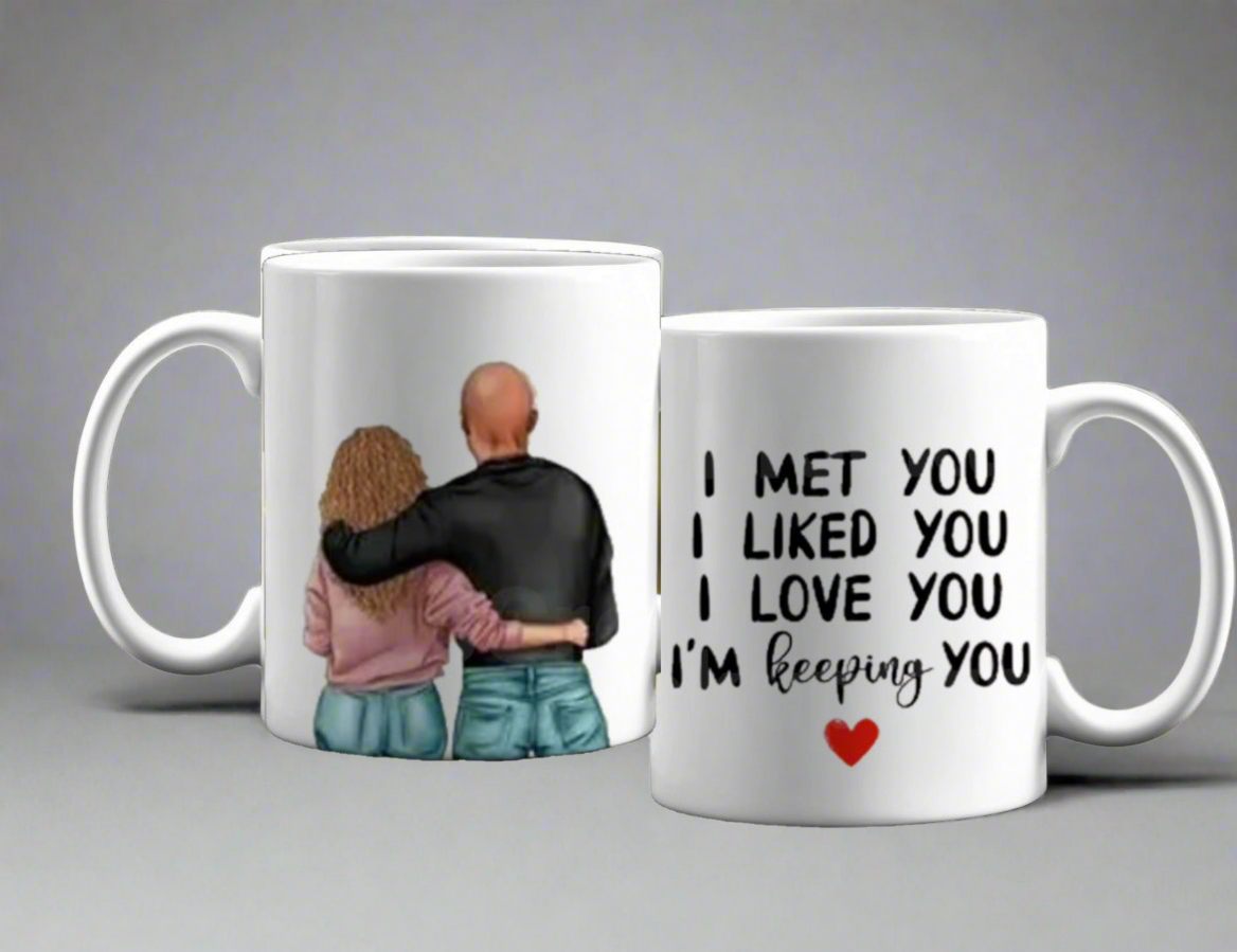 The Couples Ceramic Mug by Kreative Kreationz is a perfect romantic gift, featuring one mug with a couple embracing from behind, and the other stating "I MET YOU, I LIKED YOU, I LOVE YOU, I'M KEEPING YOU" with a red heart. Ideal for couples who cherish their connection.