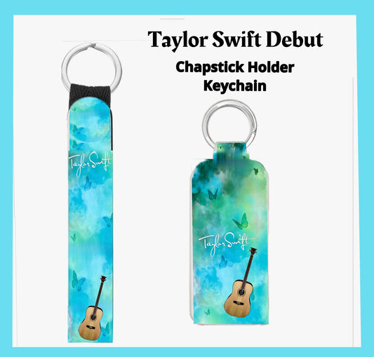 This vibrant Taylor Swift Debut Chapstick Keychain Holder by Kreative Kreationz has a blue-green gradient, "Taylor Swift" text, a guitar illustration, butterfly motifs, and a metallic ring for easy attachment.