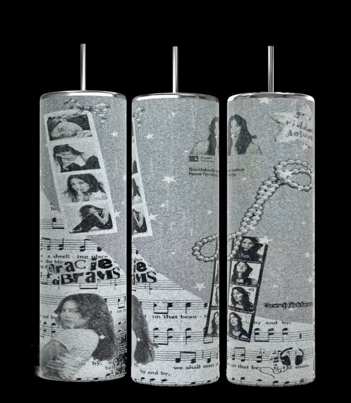 The Kreative Kreationz Gracie Abrams Picture Collage 20oz Skinny Tumbler features a grayscale collage design that includes images of a woman, musical notes, filmstrips, stars, and text elements. These stylish cylindrical tumblers come with reusable straws protruding from the tops.