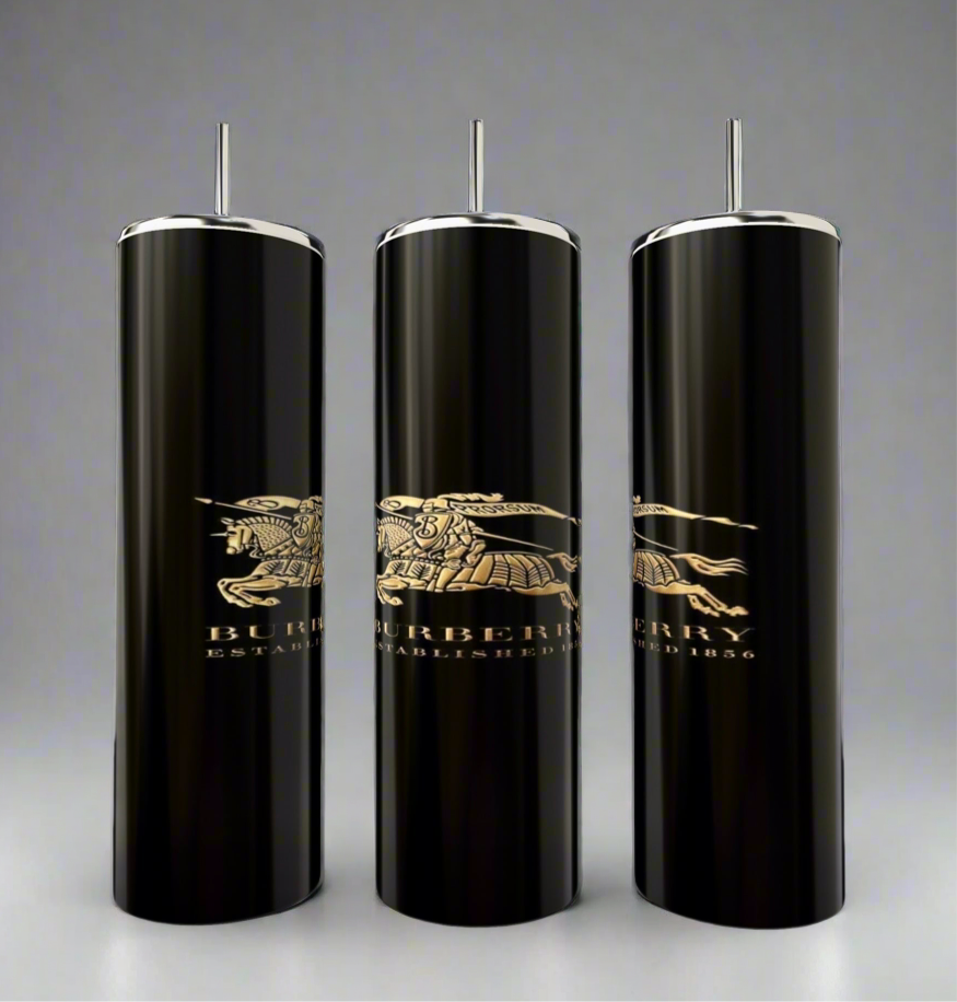 The Burberry 20oz Skinny Tumblers by Kreative Kreationz feature three elegant black cylindrical designs with silver accents and a gold Burberry logo, including "Established 1856" and an equestrian knight. They offer double-wall insulation for perfect temperature and come with a reusable straw.