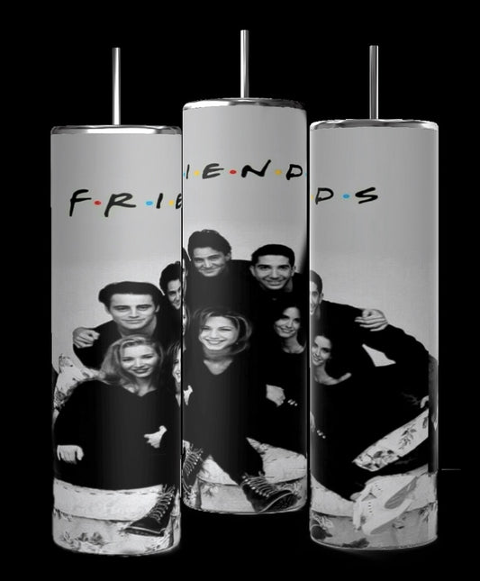 A trio of Kreative Kreationz's "Friends b&w 20oz tumblers" features a black-and-white image of six smiling friends in a playful stack. The middle tumbler, known for its durable construction, is slightly behind the others and displays the word "FRIENDS" in colorful letters above the image.