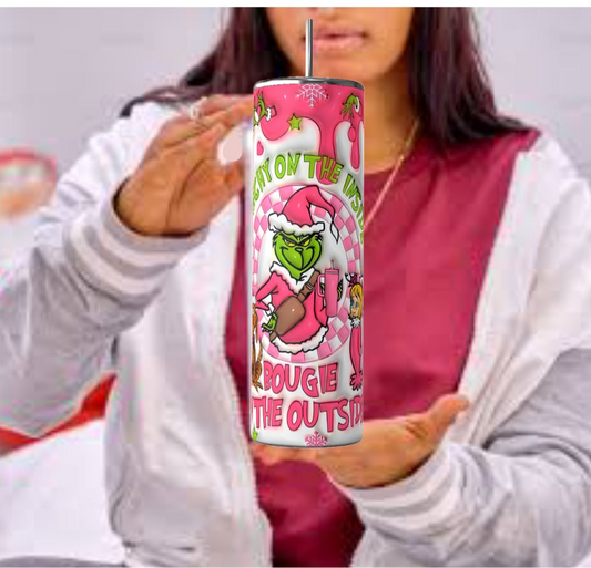 In a casual outfit, a person holds a vibrant can featuring a cartoon character in a Santa suit, highlighting the text "Bougie the Outside" with holiday graphics, echoing festive drinkware from Kreative Kreationz's Bougie Grinch Christmas 20oz Tumbler collection.