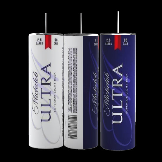 Three Michelob Ultra beer cans are displayed: one with a white background, another showcasing a barcode, nutritional data, and text, and the third boasting a dark blue background. Nearby is a sleek 20 oz stainless steel skinny tumbler from Kreative Kreationz featuring the Michelob Ultra logo. The labels on the cans indicate the beer contains 2.6 grams of carbs and 96 calories.