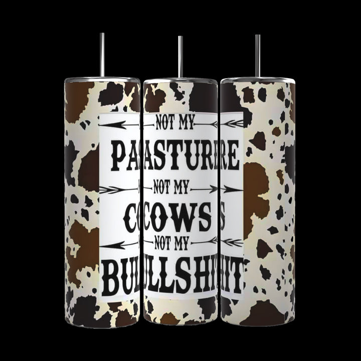 Three Kreative Kreationz "Not my Cows Not My Pasture" 20oz Stainless Steel Tumblers with durable construction, arranged side-by-side against a black background. These cow-print cylindrical objects feature the text, "Not my pasture, not my cows, not my bullshit," on one side for everyday use.