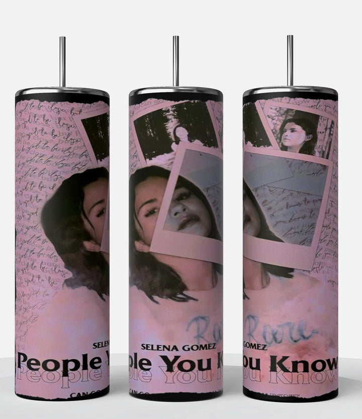 Introducing the Selena Gomez People You Know 20oz Stainless Steel Tumbler by Kreative Kreationz, featuring a vibrant collage design with images of a woman's face, pink Polaroid frames, and the text "SELENA GOMEZ" alongside other partially visible words. This sleek tumbler comes with a reusable straw and is showcased upright on a white platform against a striking black background.