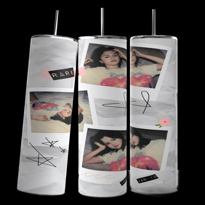 Three tall tumblers are decorated with images of Selena Gomez in different poses; one in a white dress, one with a serious expression, and one in casual attire. The designs, reminiscent of intricate Stanley cups, are embellished with flowers, leaves, hearts, and text like "Rare," "Trust," "same old love,” and "you left me in pieces.