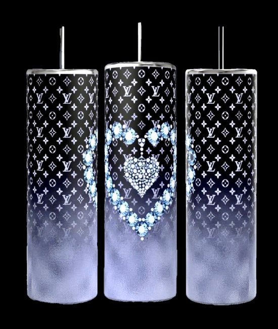 Three LV Designer 20oz Tumblers by Kreative Kreationz feature a tall, cylindrical design with spill-proof metallic lids and straws. They showcase a black and white designer pattern, with the middle tumbler adorned with a heart design crafted from blue flowers. Each tumbler transitions to a gradient foggy gray towards the bottom.