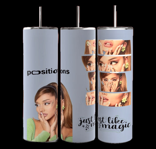 Three tall, cylindrical tumblers are arranged side by side. These Ariana Grande 20-ounce Skinny Tumblers from Kreative Kreationz feature images of a seated woman wearing green and holding her chin. One reads "positions," another says "just like magic," while the rightmost has multiple close-up shots of the woman's face.