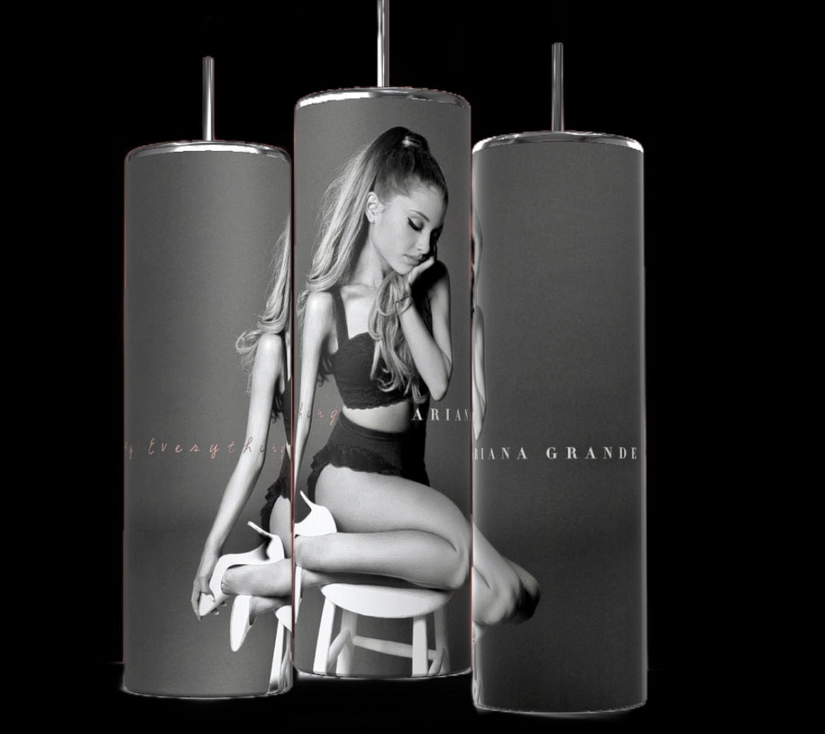 Three Ariana Grande Thank You Next 20oz Stainless Steel Tumblers from Kreative Kreationz are shown, each featuring a grayscale image of a woman sitting on a stool in a black outfit. The text "Ariana Grande" is visible on each tumbler. The black background accentuates the sleek and stylish design of these Ariana Grande tumblers.