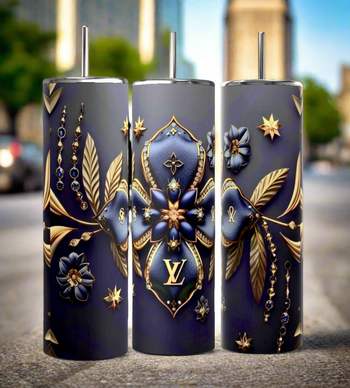 Three dark blue cylindrical tumblers, inspired by the luxury GUCCI Diana design and crafted by Kreative Kreationz, each featuring a textured pattern. These elegant tumblers boast prominent gold and red buckle designs, include a reusable straw, and flaunt a sleek, minimalistic aesthetic against a dark blue background. Each tumbler has an impressive 20 oz capacity.
