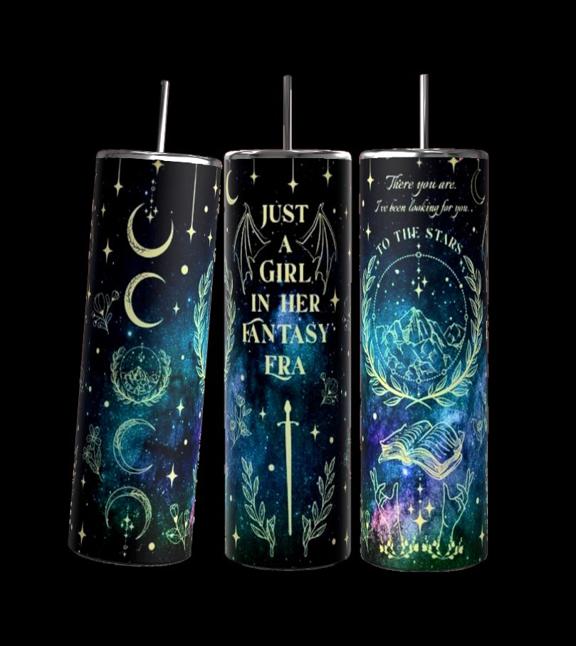 A set of three 20oz tall tumblers from Kreative Kreationz, each with spill-proof black lids and straws. They feature celestial designs including stars, moons, and mystical symbols. The central tumbler prominently displays the phrase "Just a Girl in Her Fantasy" alongside fantasy-inspired illustrations, highlighting its durable construction.