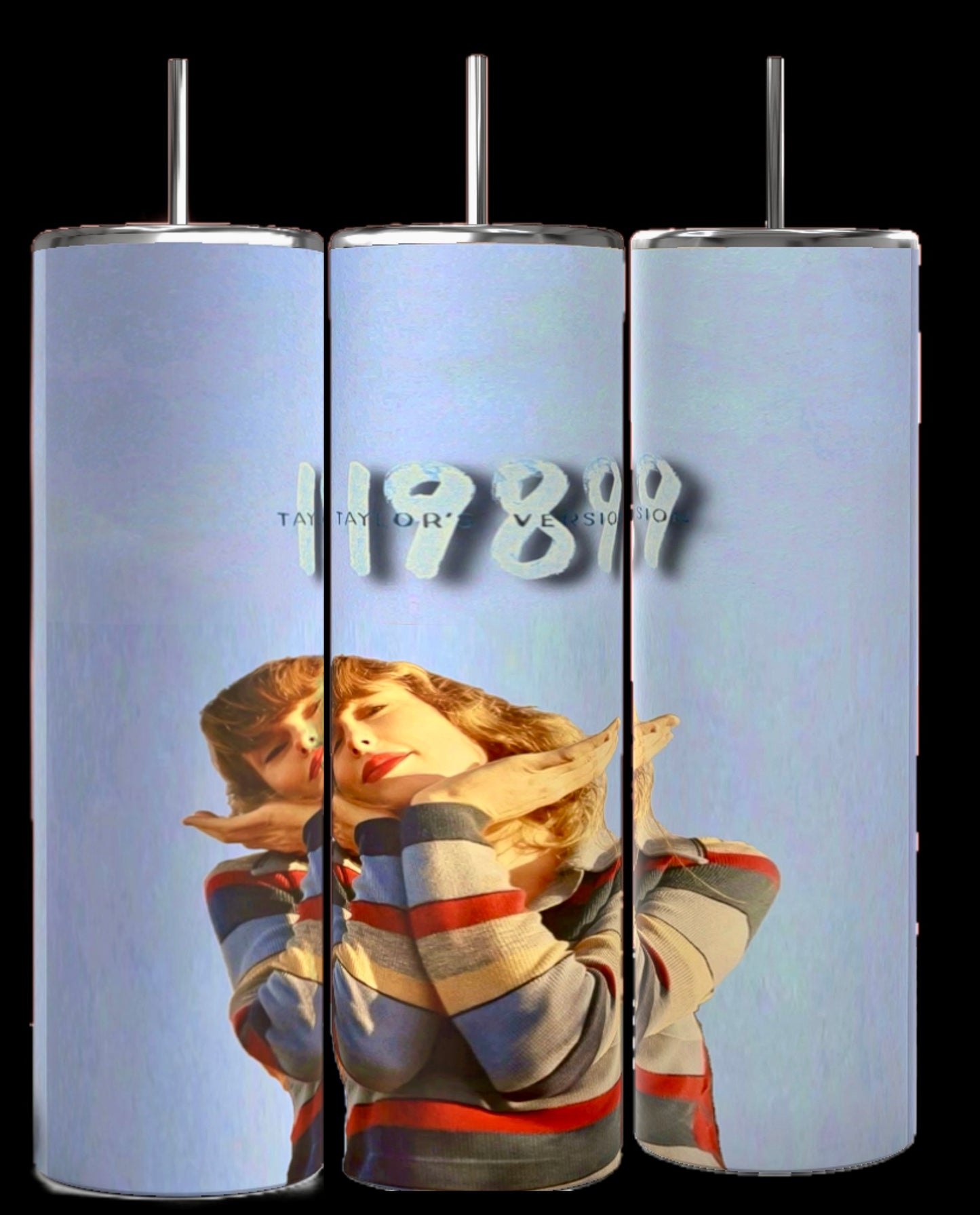 Three cylindrical tumblers from the "1989 Series | Taylor Swift 20oz Tumbler" collection by Kreative Kreationz are adorned with an image of Taylor Swift wearing a striped shirt, posing with her hands near her face. The durable construction keeps beverages hot or cold. The background displays the numbers "1989" and some text, partially obscured by lighting effects.